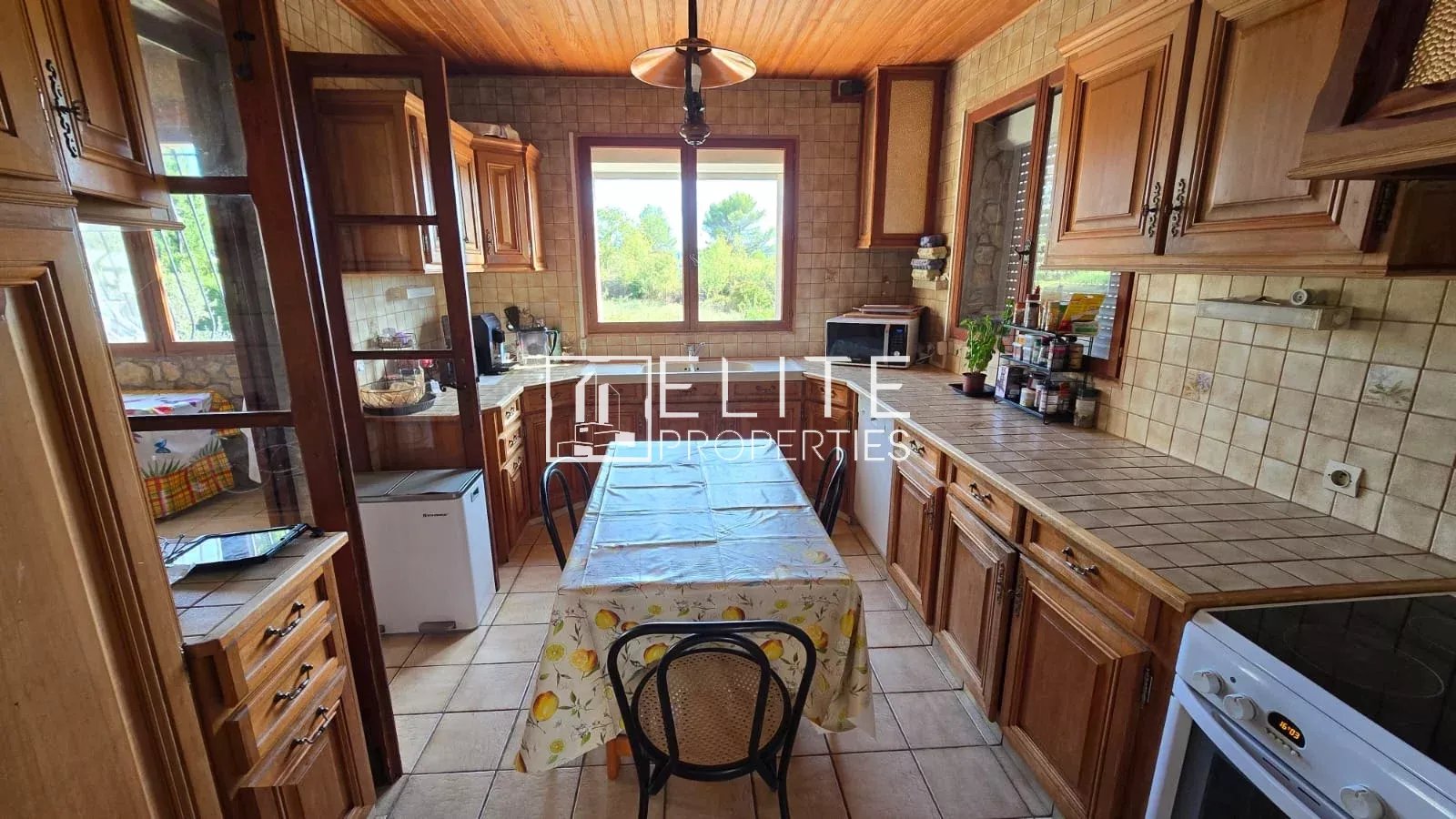 Cuisine de maison en pierre à Mouans-Sartoux Cuisine d'une maison en pierre avec meubles en bois et table à manger, située à Mouans-Sartoux.