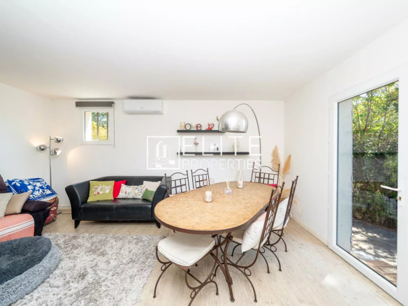 Intérieur d'une maison à Grasse avec salon et salle à manger, mobilier moderne et lumière naturelle.