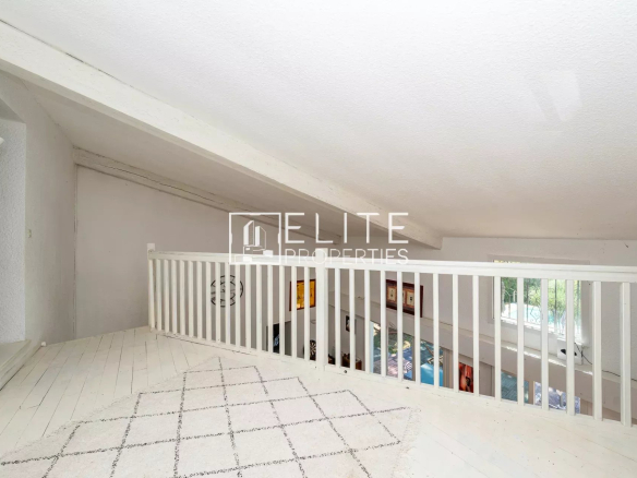 Intérieur d'une maison avec un balcon et un espace de vie lumineux.