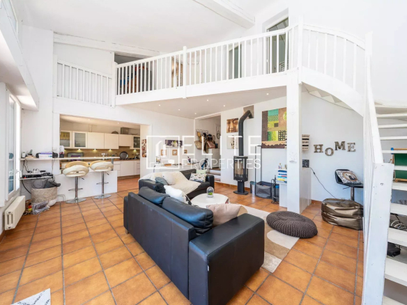 Intérieur d'une maison à Grasse avec salon spacieux, cuisine ouverte et mezzanine.