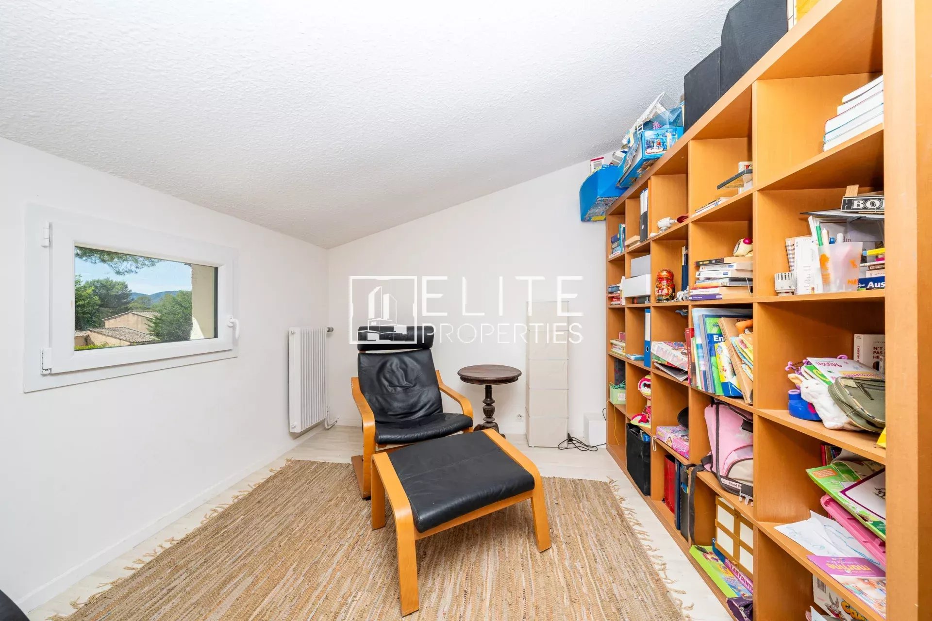Intérieur d’une maison à Grasse Saint-Jacques Intérieur d'une maison avec un fauteuil et une bibliothèque, Grasse Saint-Jacques.