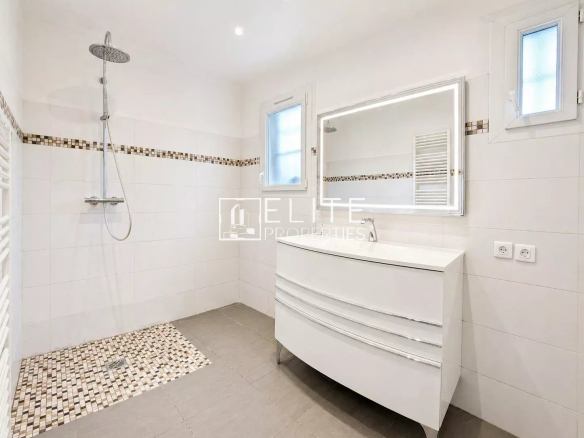 Modern bathroom with walk-in shower and vanity unit.