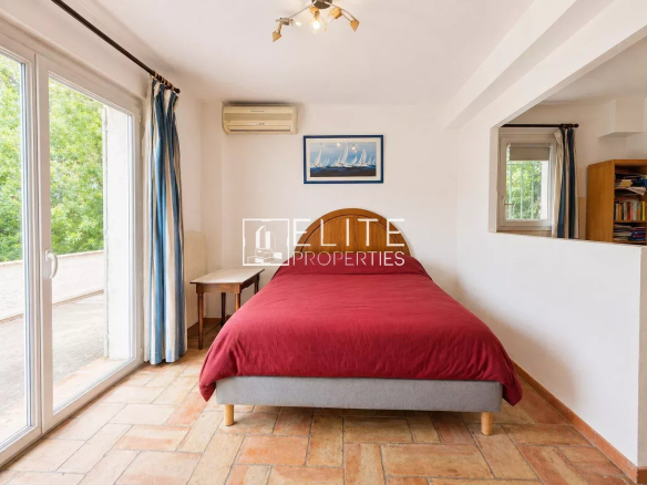 Room with double bed and view of the outside in a house in La Roquette-sur-Siagne.
