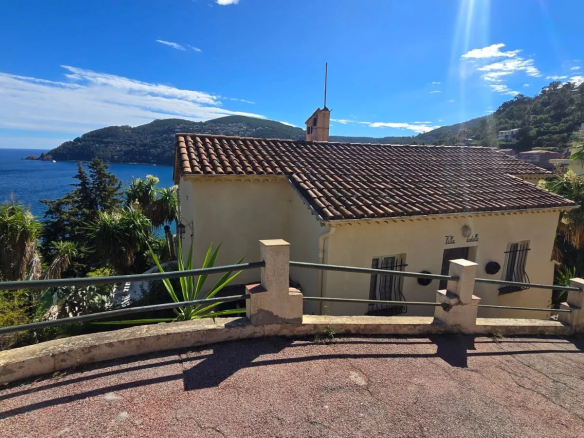 Maison à Théoule-sur-Mer avec vue mer panoramique, terrain en pente et accès proche des plages.