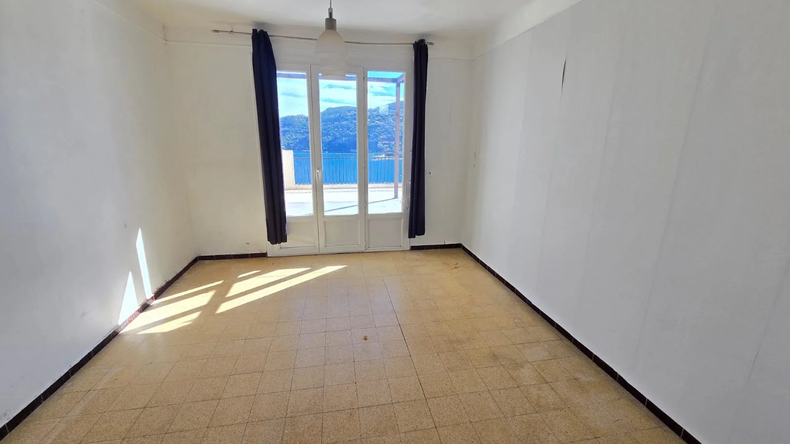 Intérieur d’une maison à Théoule-sur-Mer Intérieur d'une maison à rénover avec vue sur la mer, fenêtres ouvertes.