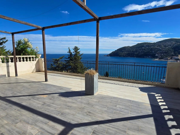 Terrasse avec vue panoramique sur la mer à Théoule-sur-Mer, entourée de végétation.