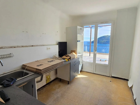 Cuisine d'une maison à rénover avec vue sur la mer à Théoule-sur-Mer.