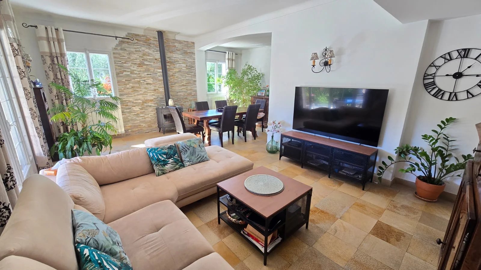 Intérieur d’une maison à Mouans-Sartoux Intérieur d'une maison moderne avec un salon lumineux, un canapé et une télévision.