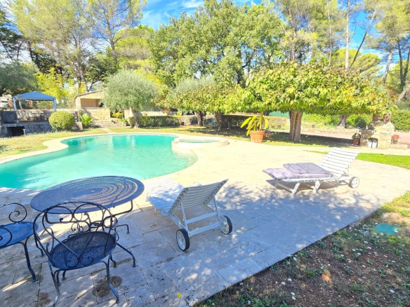 Piscine et espace extérieur d'une maison avec chaises longues et table, entourée d'arbres à Mouans-Sartoux.