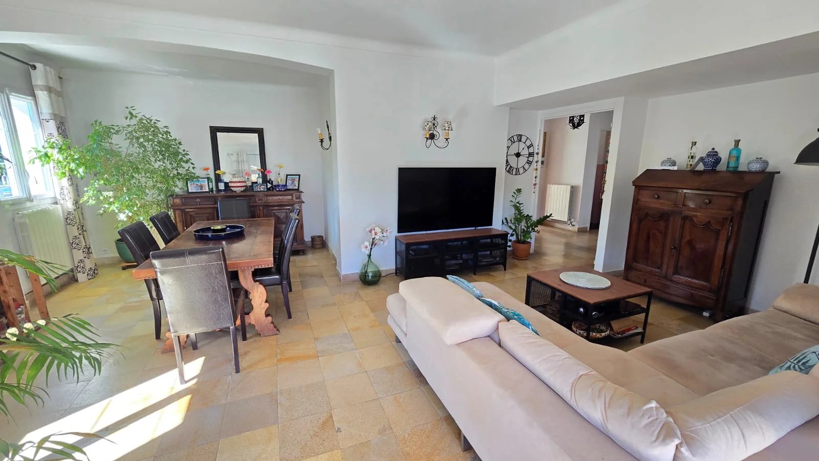 Intérieur de maison à Mouans-Sartoux Intérieur d'une maison moderne avec salon et salle à manger, meubles en bois et télévision.
