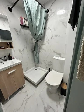 Salle de bain moderne Salle de bain moderne avec douche, lavabo et toilettes, carrelage en marbre.