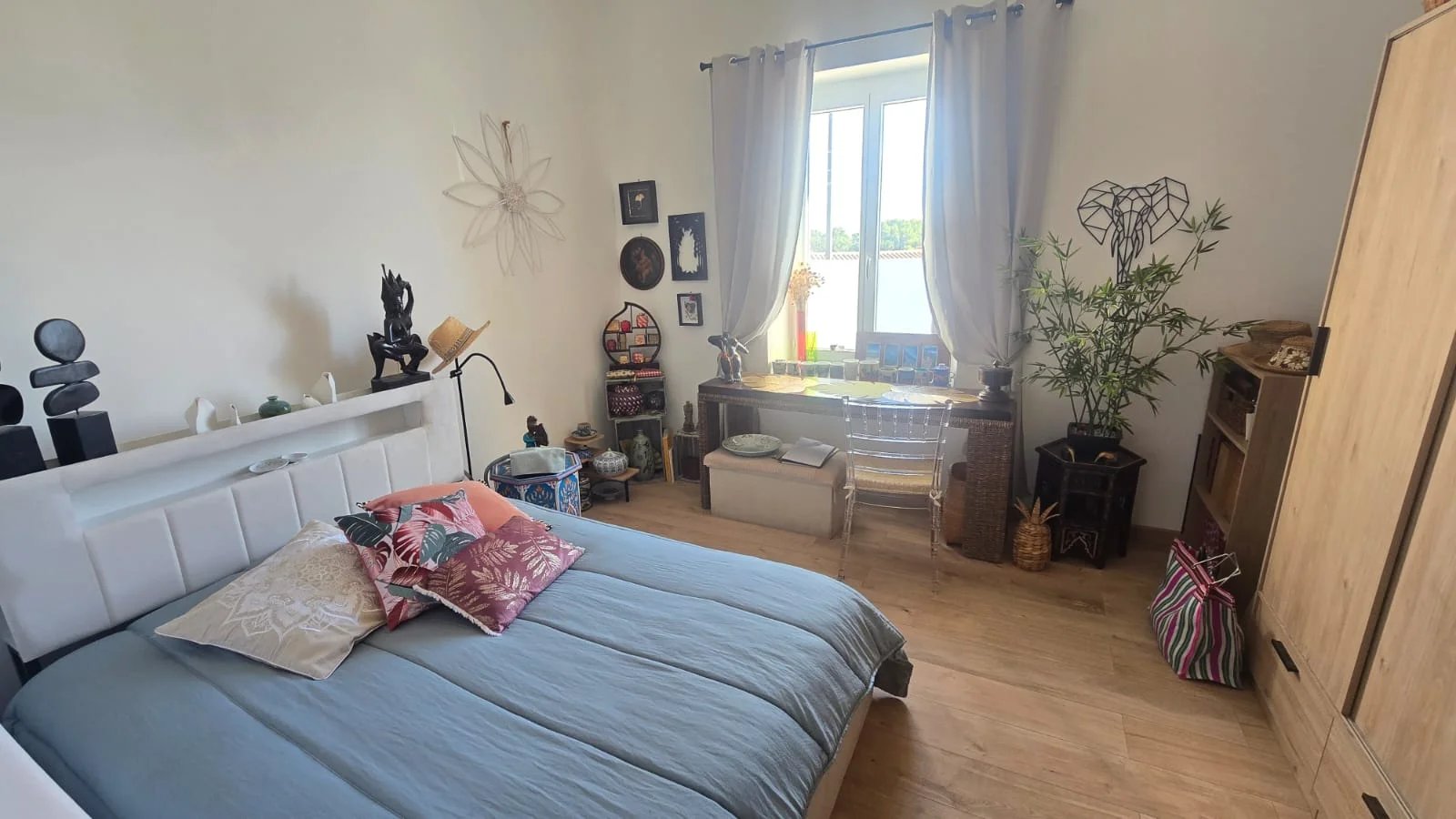 Chambre d’un logement à Roquefort-les-Pins Chambre d'un logement avec décoration moderne et fenêtre laissant entrer la lumière.
