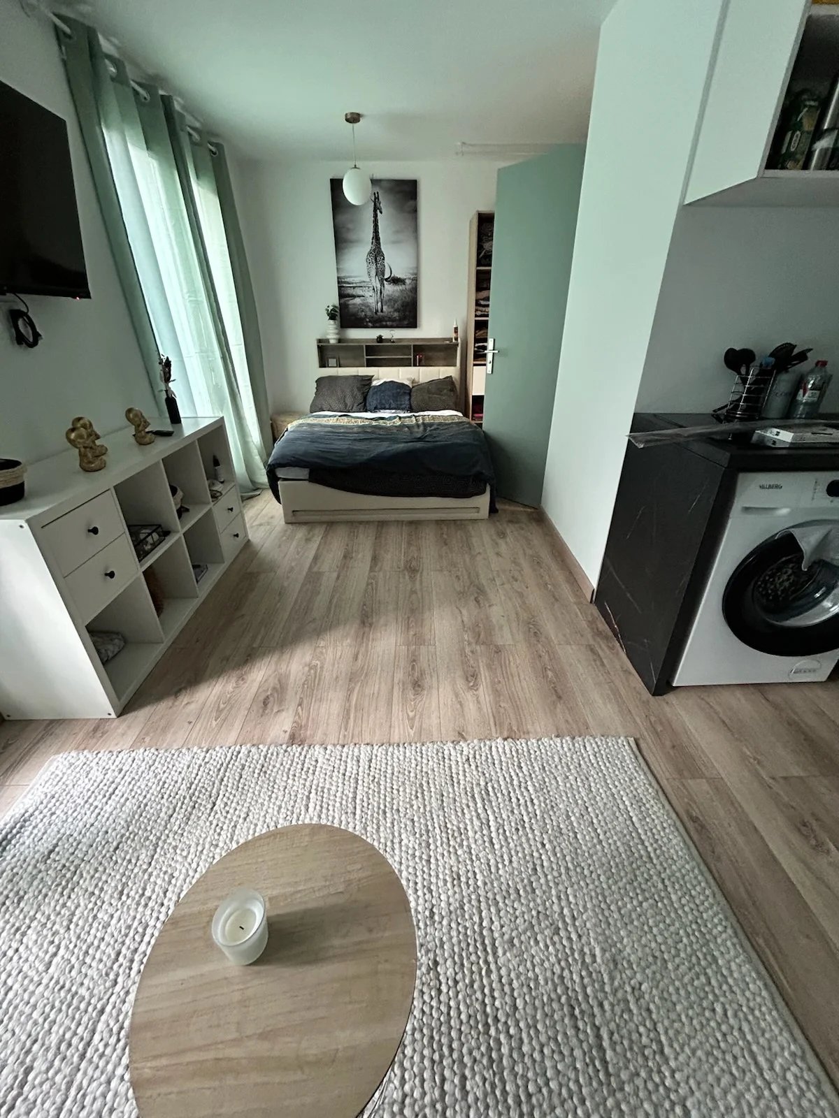 Chambre d’un logement Chambre d'un logement avec lit, table basse et machine à laver.
