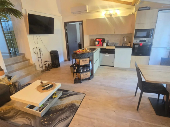 Intérieur d'un appartement avec salon, cuisine et table à manger.
