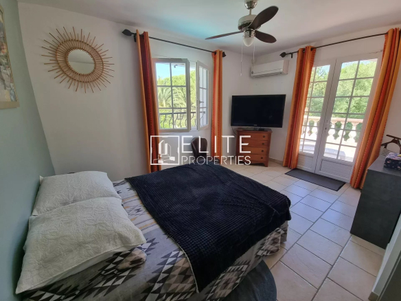 Chambre avec lit double, télévision et accès à un balcon, dans une villa à Les Adrets-de-l'Estérel.