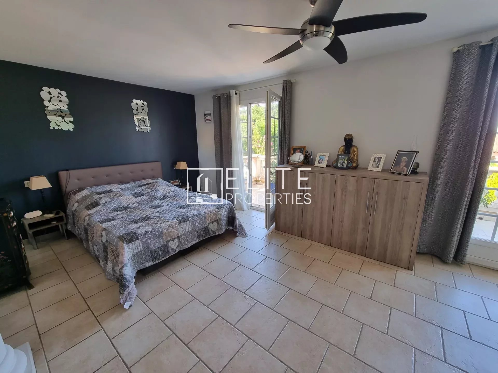 Chambre spacieuse avec lit, meubles en bois et accès à l'extérieur.
