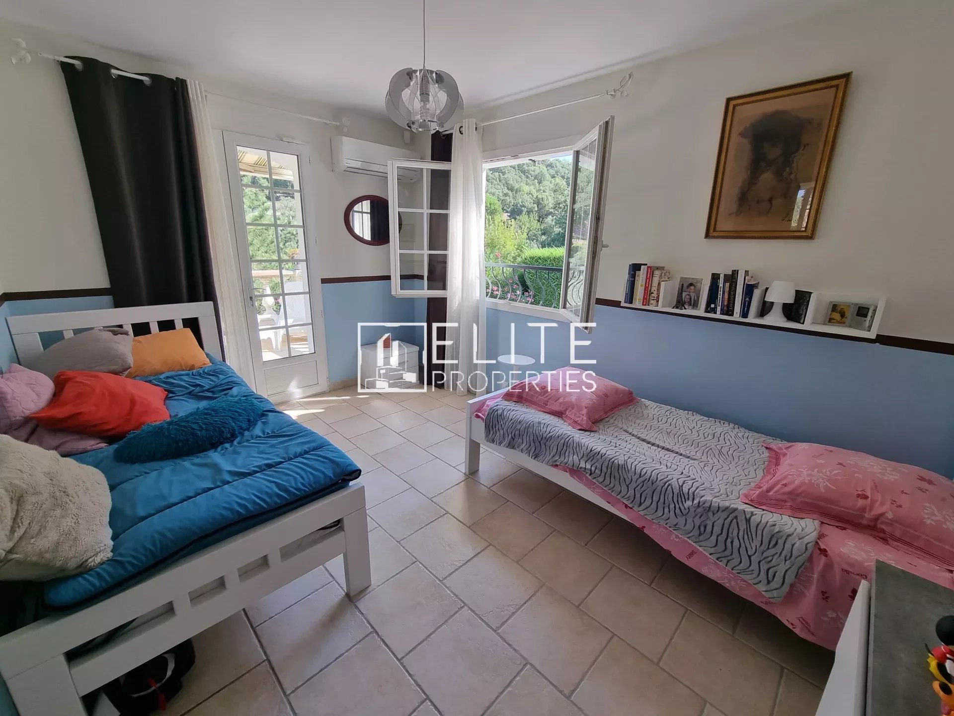 Chambre d'une villa à Les Adrets-de-l'Estérel avec lits et accès à l'extérieur.