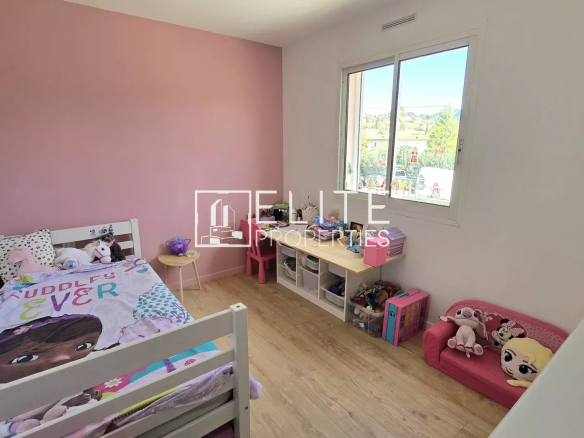 Chambre d'enfant avec lit, jouets et murs peints en rose à Grasse.