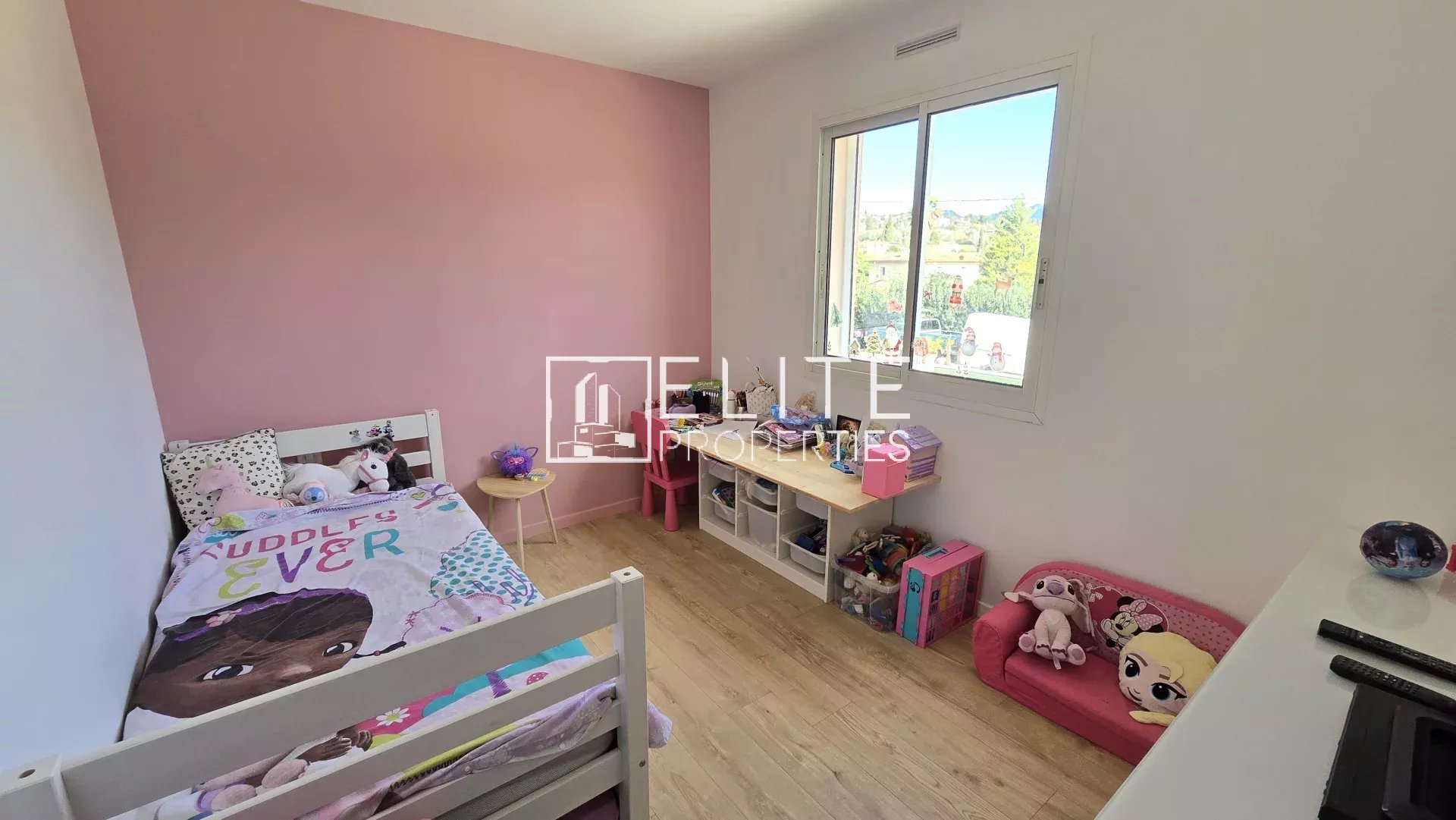 Chambre d’enfant à Grasse Chambre d'enfant avec lit, jouets et murs peints en rose à Grasse.
