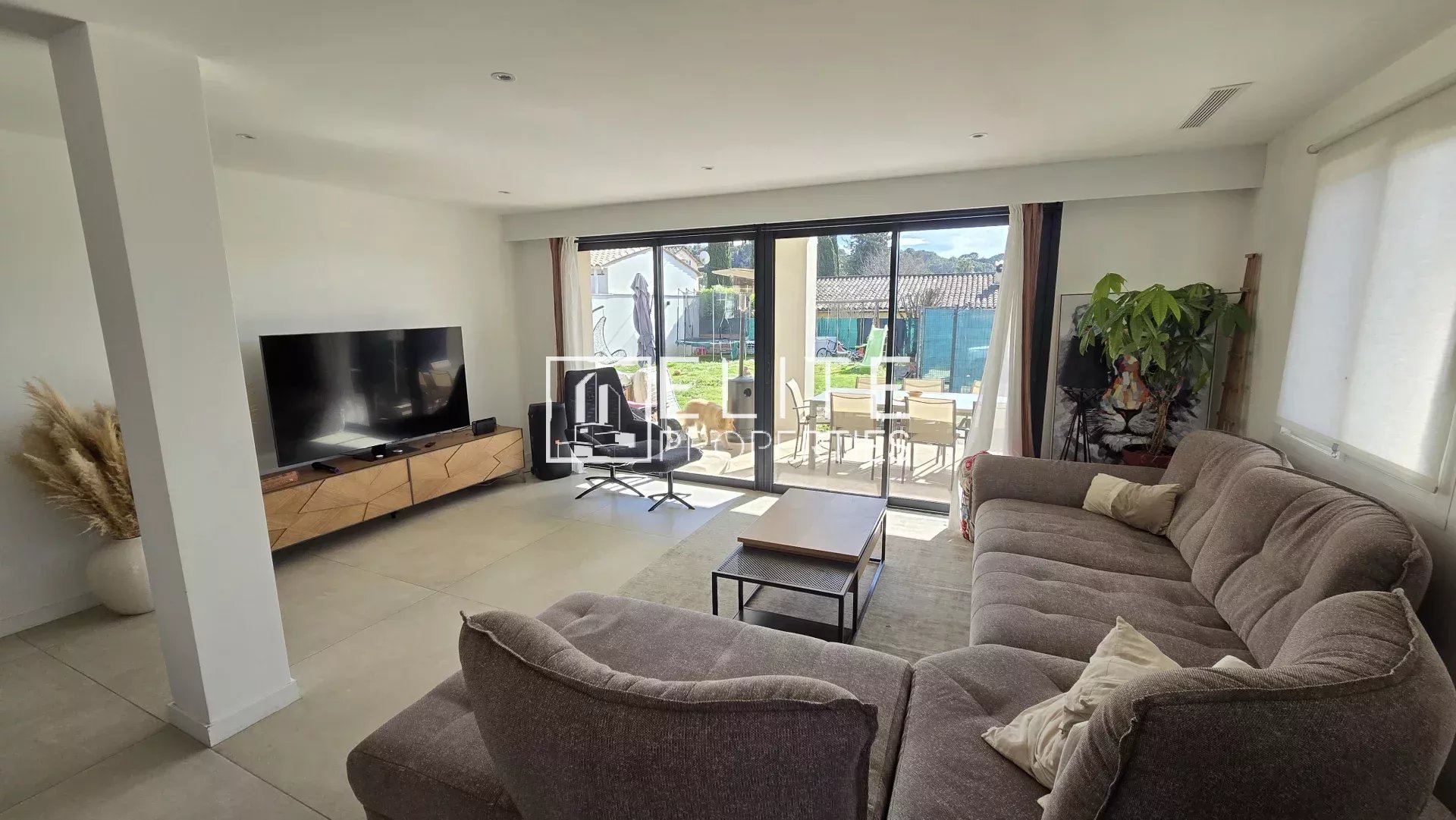 Salon d’une maison rénovée à Grasse Intérieur d'une maison rénovée avec un salon moderne et lumineux, fenêtres donnant sur le jardin.