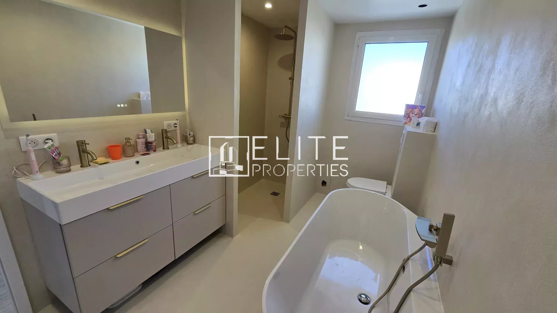Salle de bain de maison à Grasse Salle de bain moderne avec baignoire et double vasque dans une maison rénovée à Grasse.