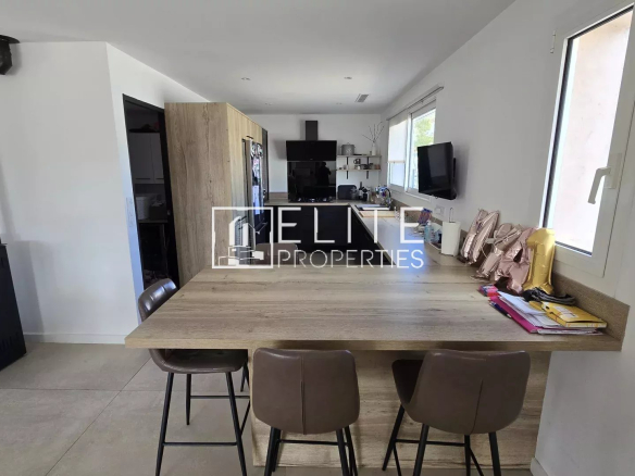 Intérieur d'une maison rénovée avec cuisine ouverte et coin repas.