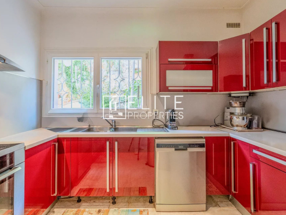 Cuisine moderne avec meubles rouges et équipements en inox.