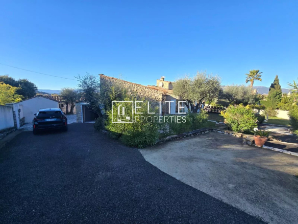 Vue extérieure d'une villa en pierre à Tanneron, avec jardin et voiture garée.