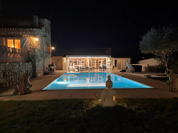 Villa en pierre avec piscine chauffée, jacuzzi et pool house à Tanneron, vue dégagée, nuit.