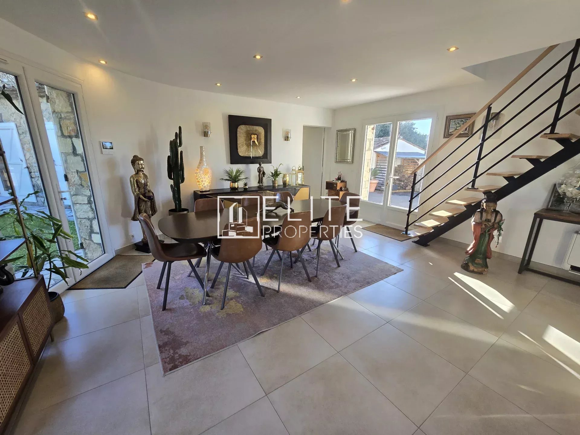 Intérieur de la villa à Tanneron Intérieur d'une villa rénovée avec salle à manger, décoration moderne et escalier en métal.