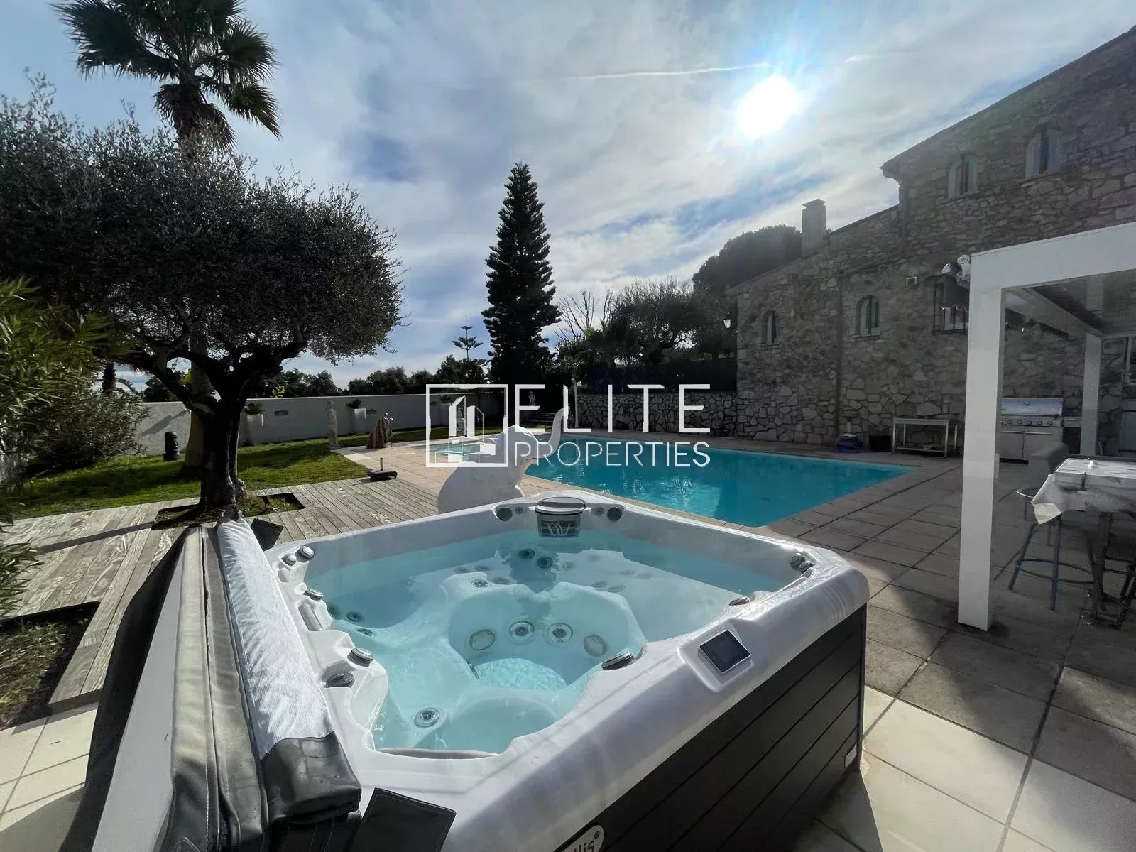 Villa avec piscine et jacuzzi à Tanneron Jacuzzi et piscine dans une villa à Tanneron, entourés d'oliviers.