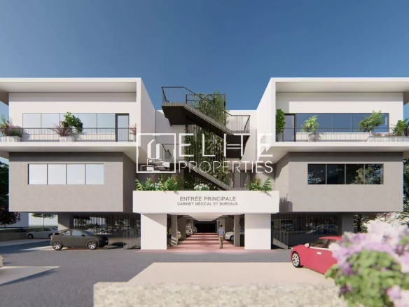 Immeuble commercial moderne avec stationnement à Grasse, façade blanche et verdure.