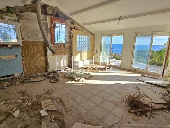 Intérieur d'une maison individuelle à rénover avec vue sur la mer à Vallauris, pièces en désordre.