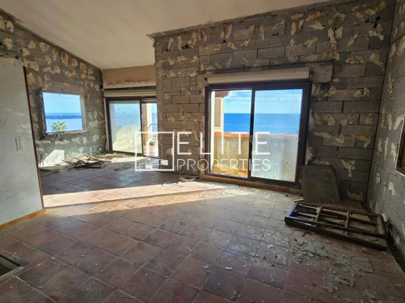 Intérieur d'une maison abandonnée à Vallauris, murs non finis, vue sur la mer à travers les fenêtres.