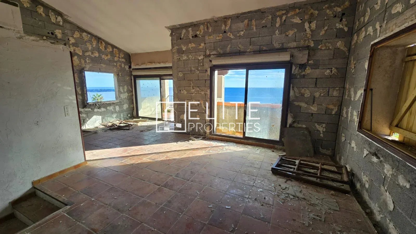 Maison individuelle à rénover à Vallauris Intérieur d'une maison abandonnée à Vallauris, murs non finis, vue sur la mer à travers les fenêtres.