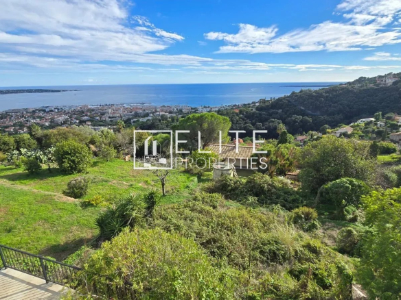 Vue panoramique sur la mer depuis une maison individuelle à Vallauris, avec un terrain verdoyant.