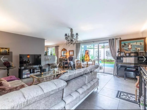 Bright living room of a 4-room apartment with a view of the pool and garden.
