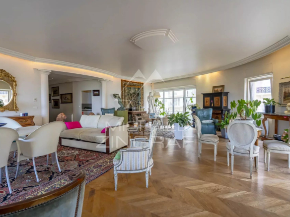 Intérieur d'un appartement lumineux avec vue sur l'océan, mobilier élégant et décoration raffinée.