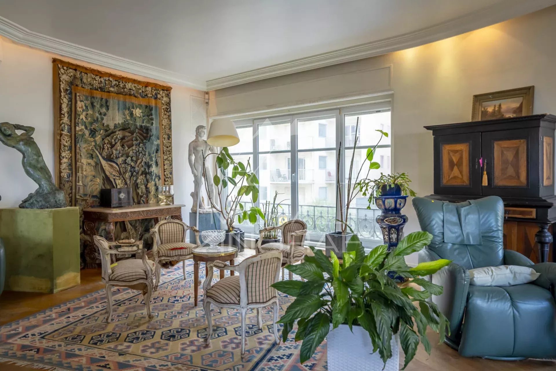 Salon d’un appartement face à l’océan à Biarritz Salon lumineux d'un appartement avec vue sur l'océan, décoré de sculptures et plantes.