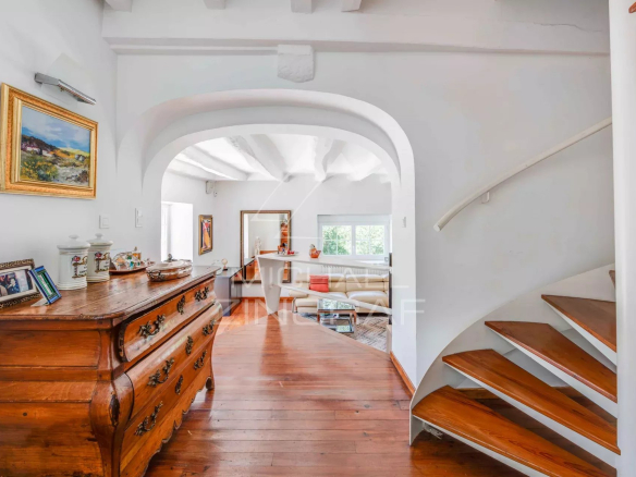 Interior of a renovated old farmhouse with a wooden staircase and white walls.