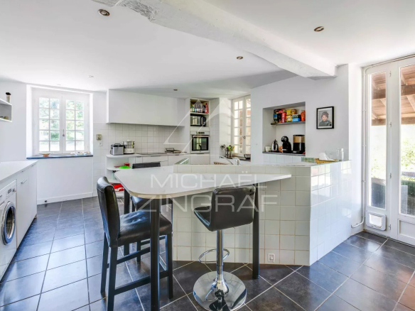Modern kitchen in a renovated old farmhouse, with bar and contemporary equipment.