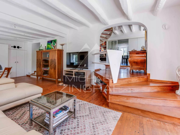 Interior of a renovated old farmhouse with living room and wooden staircase, modern and warm decor.