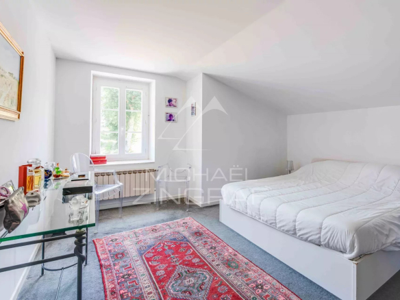 Chambre spacieuse avec lit double et tapis, lumière naturelle à Bayonne.