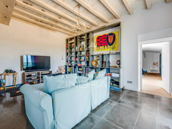 Intérieur d'une maison avec un salon élégant, cheminée et étagères, décoré avec des objets variés.