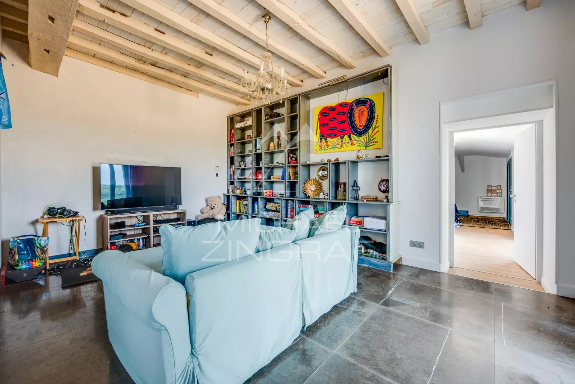 Salon d’une maison de caractère à Luxe-Sumberraute Intérieur d'une maison avec un salon élégant, cheminée et étagères, décoré avec des objets variés.