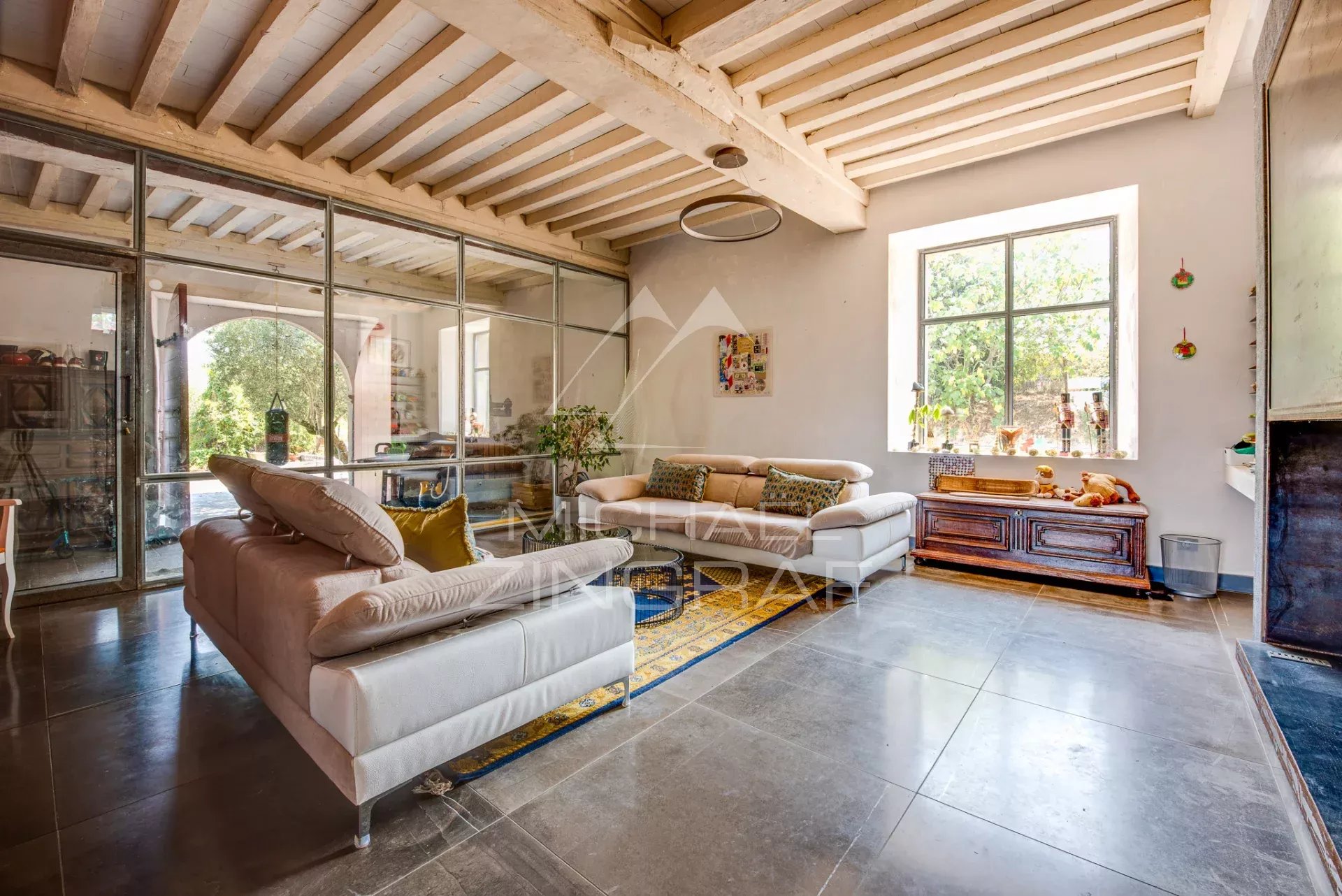 Salon d’une maison de caractère à Luxe-Sumberraute Intérieur d'un salon élégant avec cheminée et grandes fenêtres dans une maison de caractère.