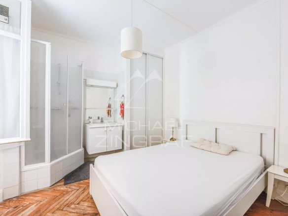 Chambre d'un appartement à Biarritz avec salle de bain attenante et décoration sobre.