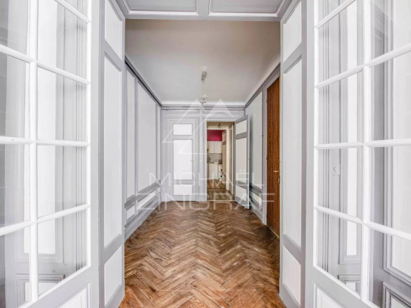 Hall d'entrée d'un appartement spacieux avec parquet et portes vitrées à Biarritz.