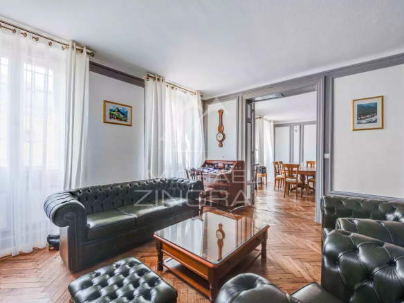 Living room of a 105 m2 apartment in Biarritz with leather sofa and period fireplace.