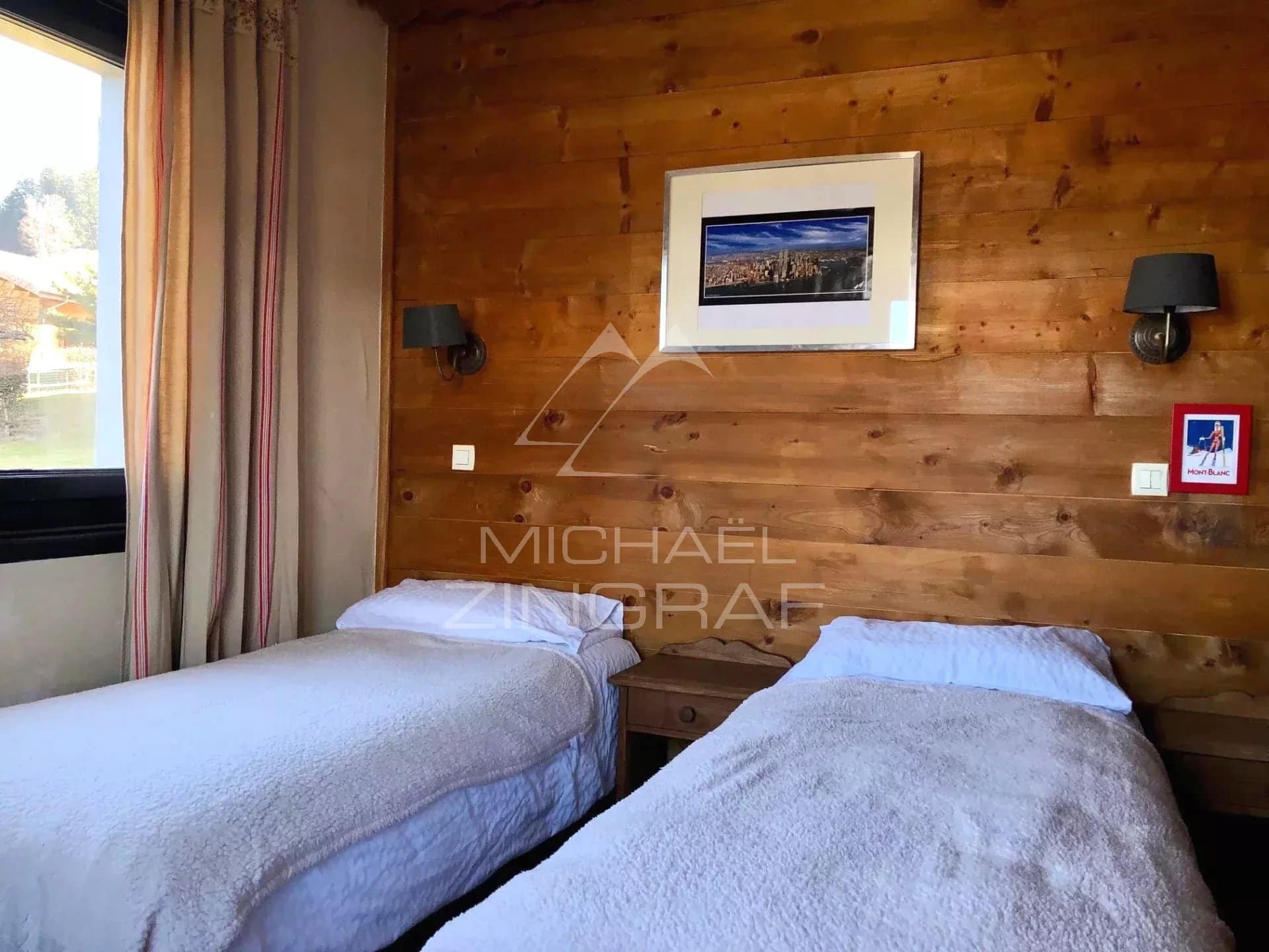 Hotel room with two single beds and wood paneling in Combloux